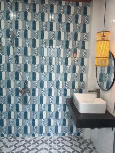 a bathroom with a sink and a tiled wall at Villa RonRoy Hà Tiên in Hà Tiên +40 photos