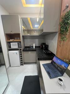 a laptop sitting on a counter in a kitchen at Residencial Ibiapaba - APARTAMENTO COMPLETO in Camocim
