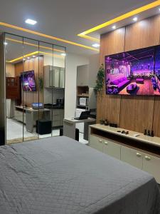 a room with a large bed and a tv on a wall at Residencial Ibiapaba - APARTAMENTO COMPLETO in Camocim