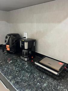 a coffee maker sitting on a counter with a laptop at Residencial Ibiapaba - APARTAMENTO COMPLETO in Camocim