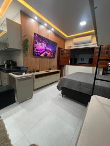 a bedroom with a bed and a tv on a wall at Residencial Ibiapaba - APARTAMENTO COMPLETO in Camocim +2 photos