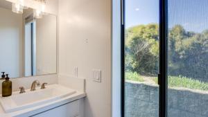 a bathroom with a sink and a mirror and a window at Strand Way A by AvantStay in Oceano +28 photos