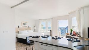 a bedroom with a bed and a kitchen with a counter at 2 Studios at Cayucan Bungalows by AvantStay in Cayucos