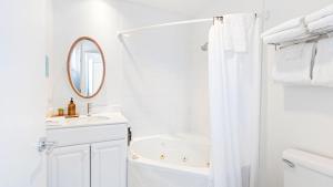 a white bathroom with a sink and a mirror at 2 Studios at Cayucan Bungalows by AvantStay in Cayucos +29 photos