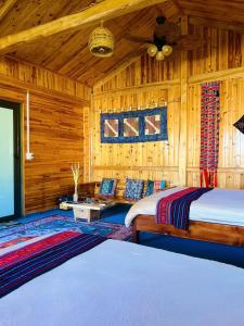a bedroom with two beds in a wooden cabin at Tao Tay House - Ta Van in Sapa