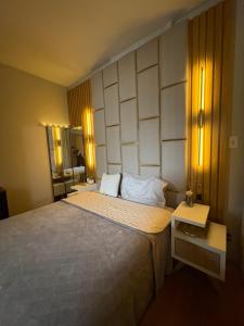 a bedroom with a large bed and a mirror at Parque plaza residence flat in São Bernardo do Campo