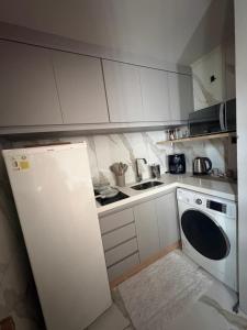 a small kitchen with a refrigerator and a dishwasher at Parque plaza residence flat in São Bernardo do Campo