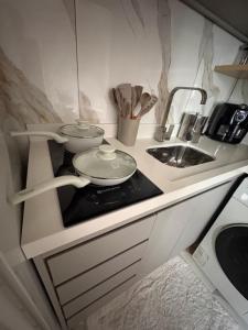 a kitchen counter with a stove and a sink at Parque plaza residence flat in São Bernardo do Campo