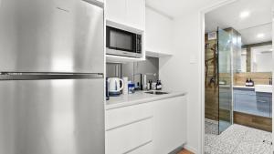 a kitchen with a stainless steel refrigerator and a microwave at The Studio at Northshore Tower in Cairns North
