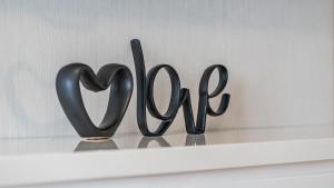 a metal sign that reads love sitting on a shelf at The Studio at Northshore Tower in Cairns North +13 photos
