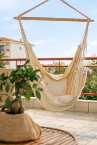 a hammock on a balcony with a plant at 3BR Suite 300mts from the Beach in Perea