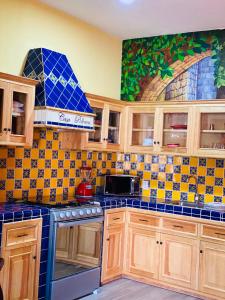 a kitchen with blue and yellow tiles on the wall at Penthouse Casa Polican in Tuxpan