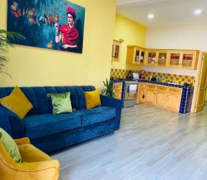 a living room with a blue couch and a kitchen at Penthouse Casa Polican in Tuxpan