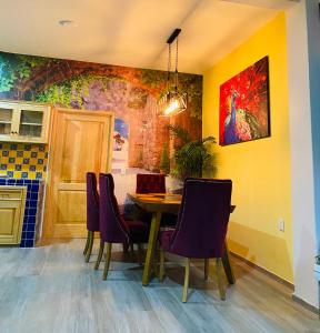 a dining room with a table and purple chairs at Penthouse Casa Polican in Tuxpan