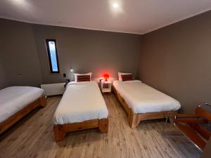 a room with two beds and a lamp in it at Chagual Los Vilos Lodging in Los Vilos