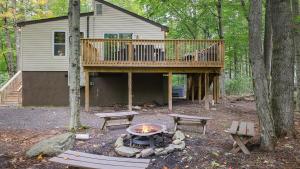 a house with a deck and a fire pit at Moshannon by AvantStay in Pocono Lake
