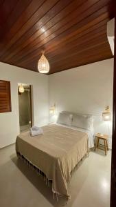 a bedroom with a large bed with a wooden ceiling at Casas Gica in Pipa