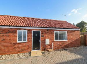 a red brick house with a black door at The Nest in Bridlington
