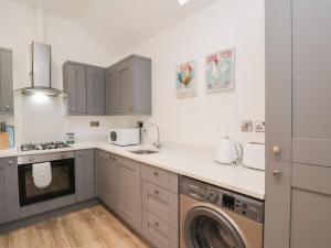a kitchen with a sink and a washer and dryer at The Nest in Bridlington
