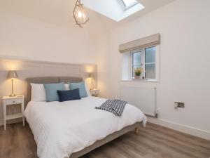 a bedroom with a large white bed and a window at The Nest in Bridlington