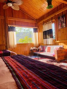 a bedroom with a bed and a couch in a room at Tao Tay House - Ta Van in Sapa