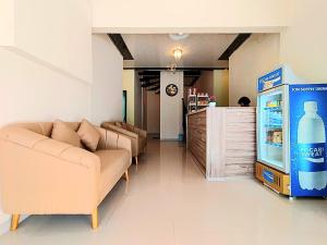 a living room with two couches and a refrigerator at Graha Citra Cirebon in Cirebon