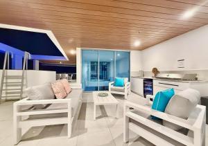 a living room with white furniture and a kitchen at Bokarina Beachfront Penthouse - Oceanfront Luxury with Exclusive Rooftop Pool & Steam Room in Bokarina +80 photos