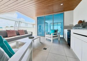 a living room with a couch and a table at Bokarina Beachfront Penthouse - Oceanfront Luxury with Exclusive Rooftop Pool & Steam Room in Bokarina