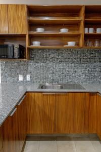 a kitchen with wooden cabinets and a sink at Hotel Punto Oriente Tonala in Tonalá +78 photos