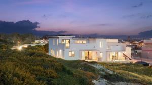 a white house on top of a hill at night at Strand Way B by AvantStay in Oceano