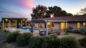 a house with a swimming pool in front of it at Devi Ranch by AvantStay in Paso Robles