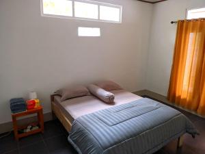 a bed in a room with a window and a bed sidx sidx sidx at De PO'ONG in Ruteng