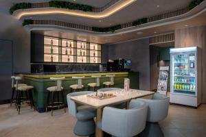 a restaurant with a bar with chairs and a refrigerator at Y Hotel Hong Kong in Hong Kong