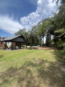 a pavilion with a black roof in a park at Cabañas Don David in Paso de la Patria