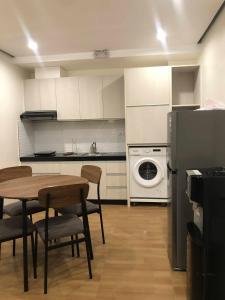 a kitchen with a table and a refrigerator and a washing machine at GQ Apartment in Aklan