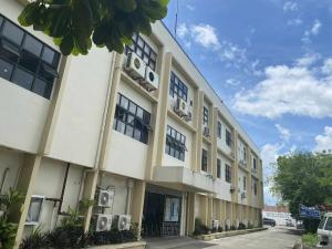 a large white building with windows on a street at GQ Apartment in Aklan