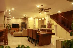 a living room with a ceiling fan and a dining room at Villa Margaux in Seminyak