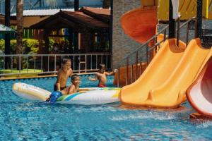 a group of young boys playing on a water slide in a pool at Love Rawai Hotel in Rawai Beach +28 photos