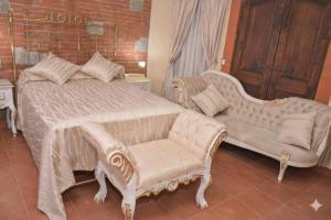 una camera da letto con un letto con un divano e una sedia di Hotel Na-anché Aeropuerto a Città di Oaxaca Altre 13 foto