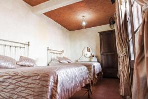 una camera da letto con due letti e soffitto in legno di Hotel Na-anché Aeropuerto a Città di Oaxaca