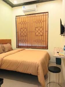 a bedroom with a bed and a window with a bedspread at Graha Citra Cirebon in Cirebon