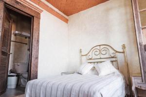 una camera da letto con un letto bianco con cuscini bianchi di Hotel Na-anché Aeropuerto a Città di Oaxaca