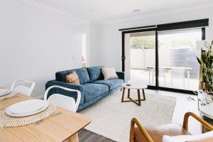 a living room with a blue couch and a table at King Bed, 3 Beds, 2 bath, Sleeps 6 in Sale