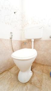 a bathroom with a white toilet in a room at Peelamedu PSG Tech Near Rooms in Coimbatore