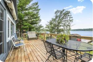 a wooden deck with a table and chairs on it at The Cozy Cub in Cross Lake +16 photos