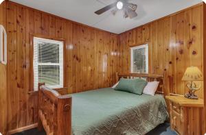 a bedroom with wood paneled walls and a bed at The Cozy Cub in Cross Lake