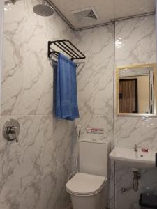 a bathroom with a toilet and a sink and a blue towel at Graha Citra Cirebon in Cirebon