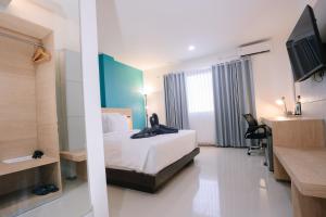 a hotel room with a bed and a desk at Hotel 88 Batulicin by WH in Batulicin