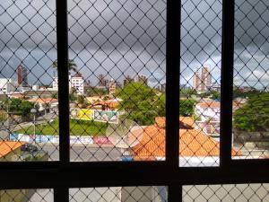 a view of a field through a chain link fence at Flat Apartamento Mobiliado na Prata in Campina Grande