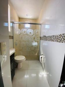 a bathroom with a shower with a toilet and a sink at Luxury Penthouse in Tuxpan +11 photos